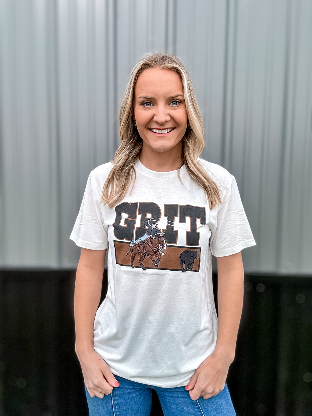 White t shirt that reads “Grit” with a breakaway roping embroidered patch design