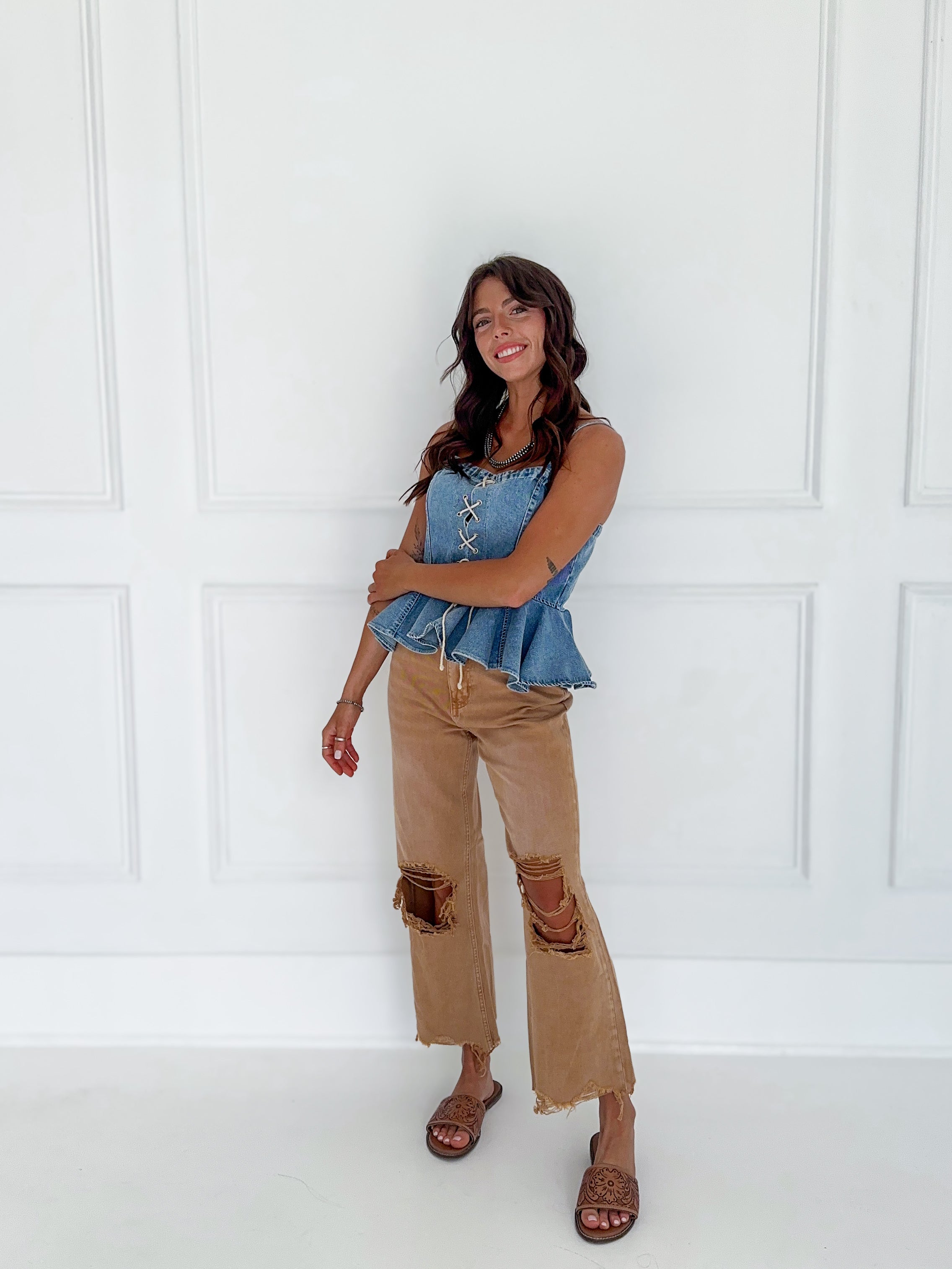 Tan high-rise crop flare jeans with a raw hem and distressed details.