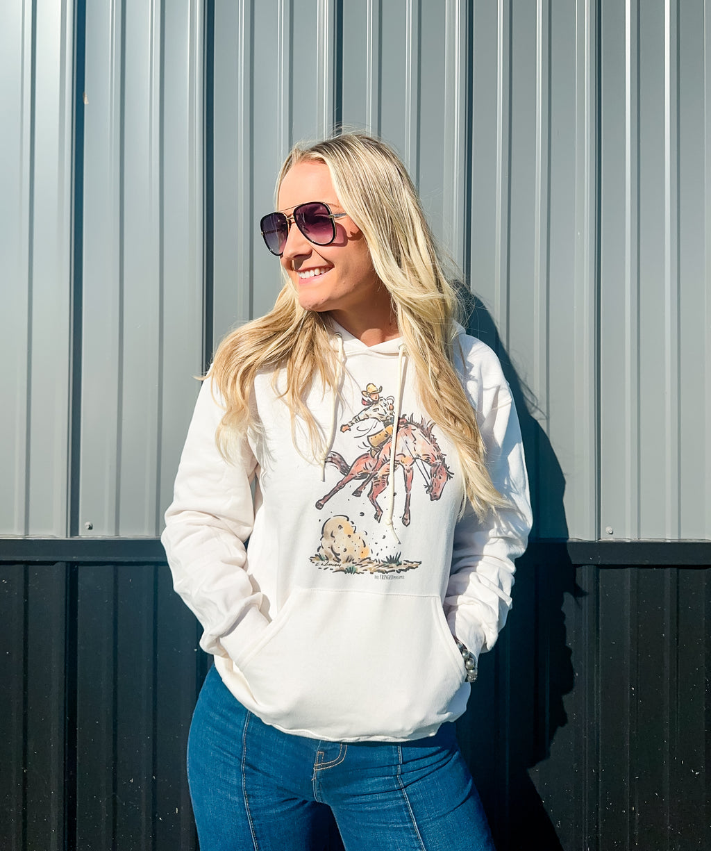 cream-colored hoodie with a bronc design.