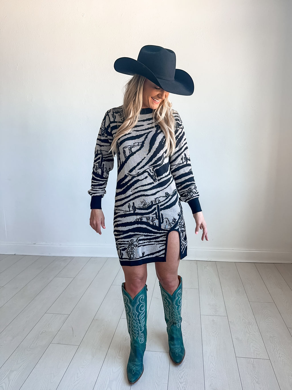 Sweater dress with round slit and black and white zebra pattern with western graphics throughout 
