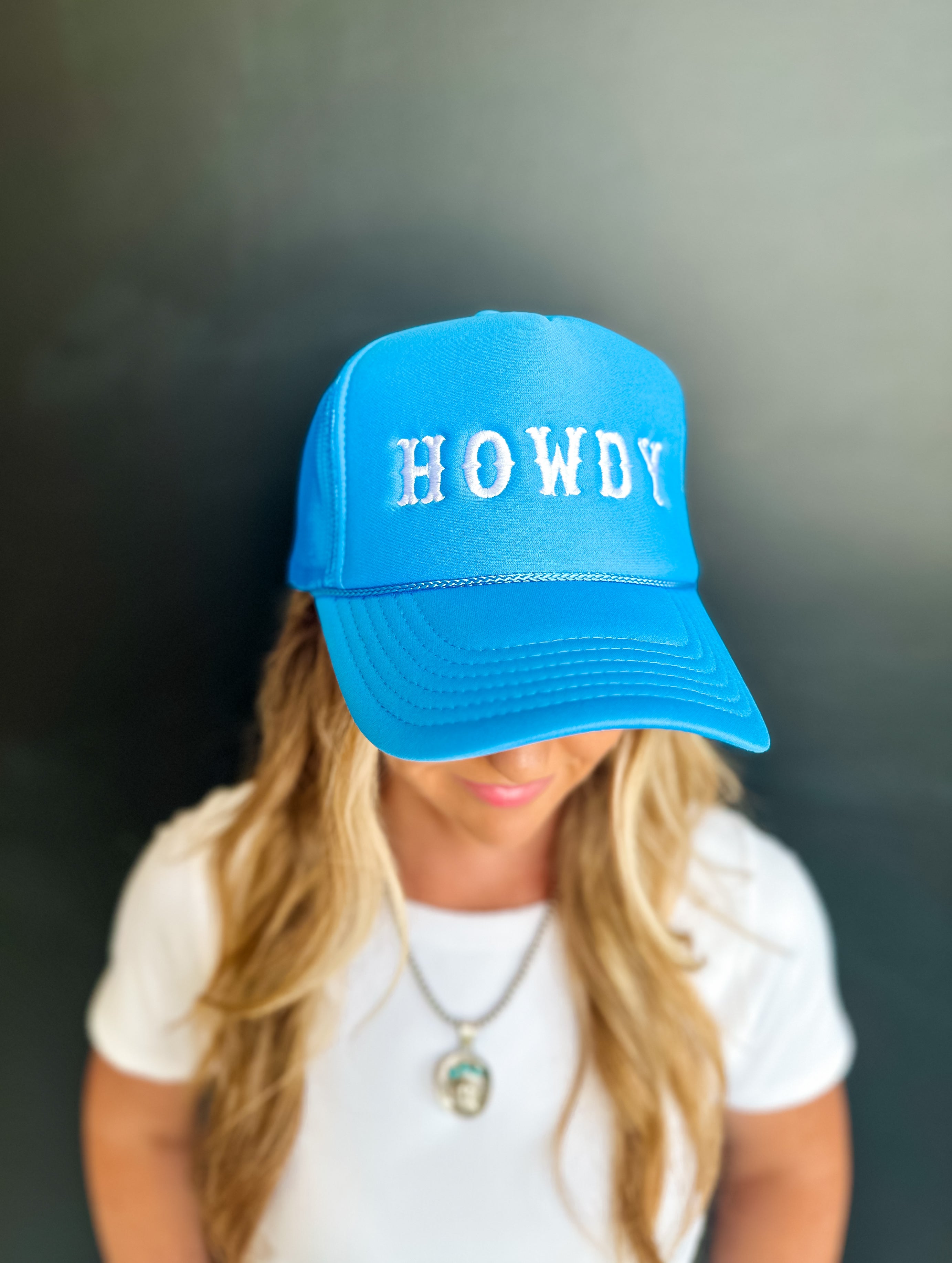 Bright blue trucker hat with the text 'HOWDY' embroidered on the front.
