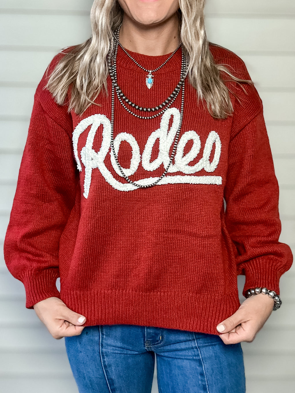 Red knit sweater with RODEO text 