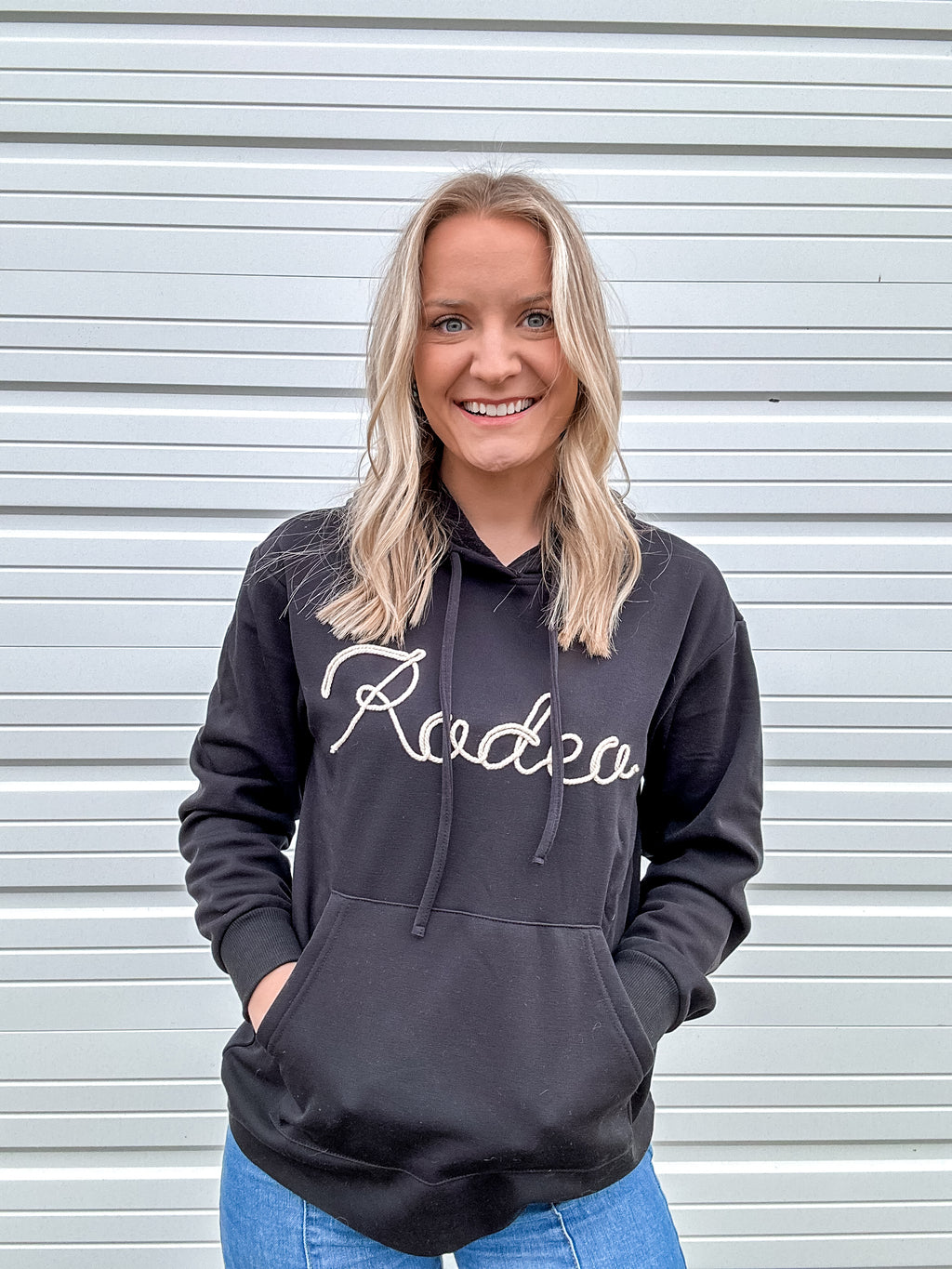Black hoodie with 'RODEO' written in white rope on the front.