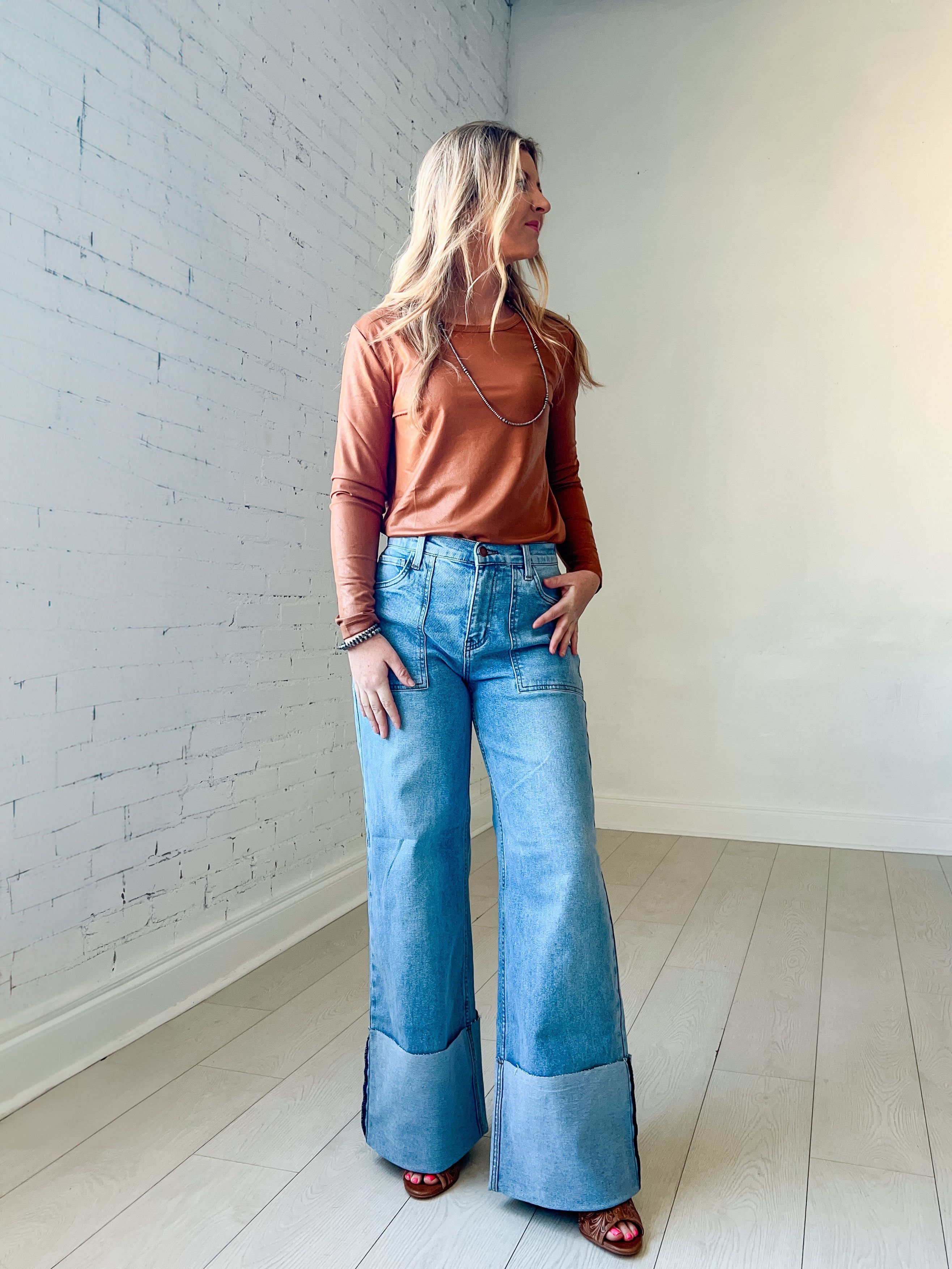 High waisted light wash wide leg jeans with a wide cuffed inseam and square pockets
