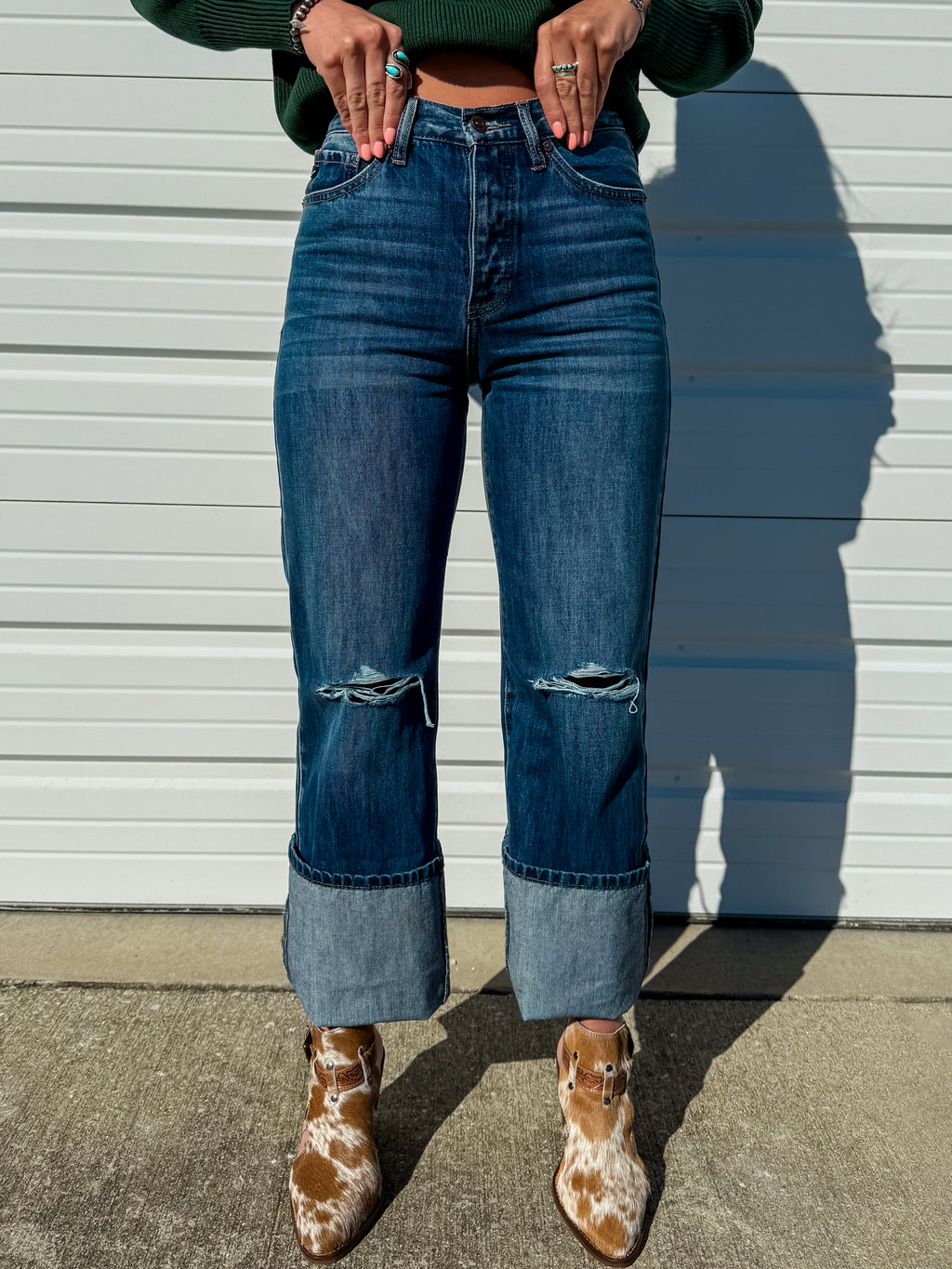 High rise dark wash straight leg jeans with distressing at the knee.