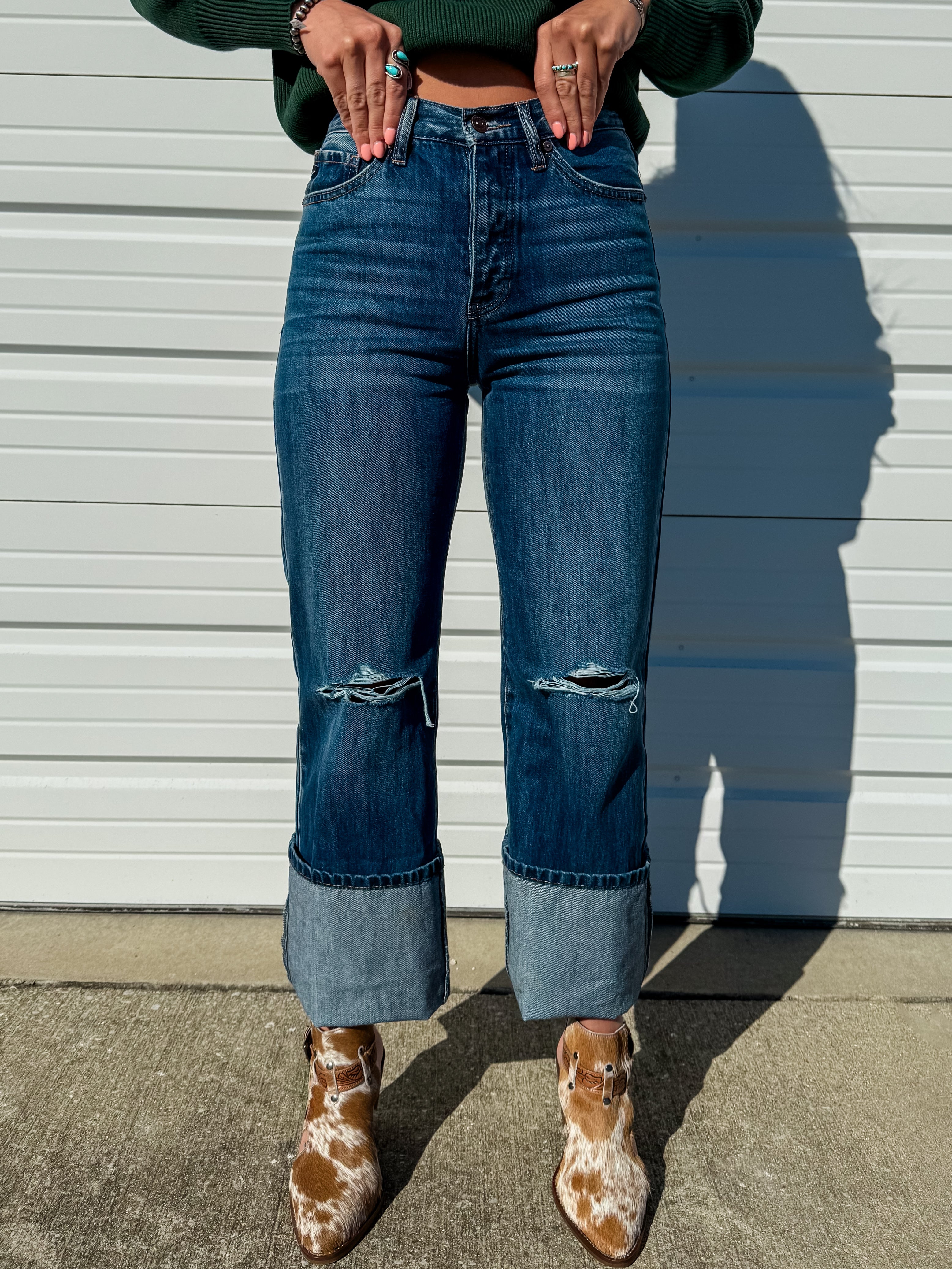 High rise dark wash straight leg jeans with distressing at the knee.