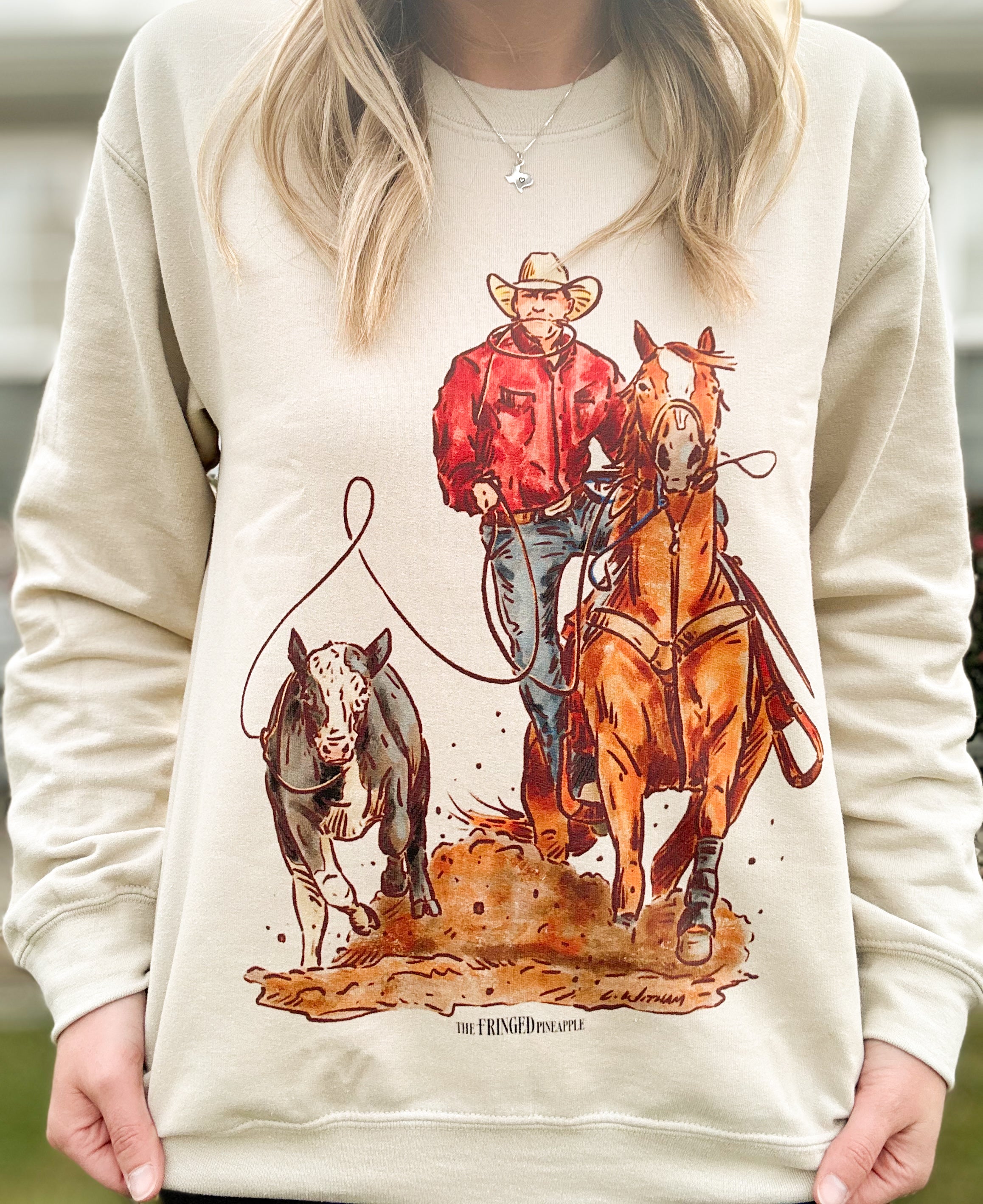Beige crewneck sweatshirt with a calf roping graphic