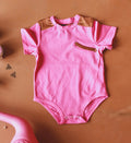 Pink baby girl onesie with arrow faux pocket design and satiny details