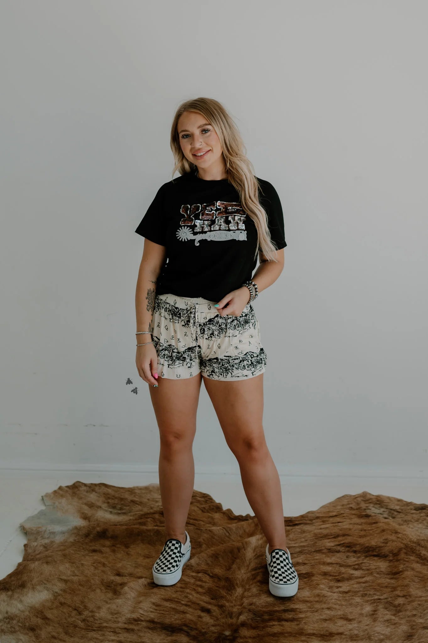 White and black drawstring lounge shorts with a vintage cowboy town graphic and western brands