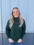 Hunter green sweater with a ribbed design and mock neck.