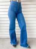 High waisted medium wash wide leg trouser style jeans with 3 button and zipper closure long inseam and raw hem with front seam and no pocket design 