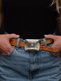 Silver rectangular belt buckle with a turquoise accent.