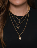 A layered gold necklace with western charms