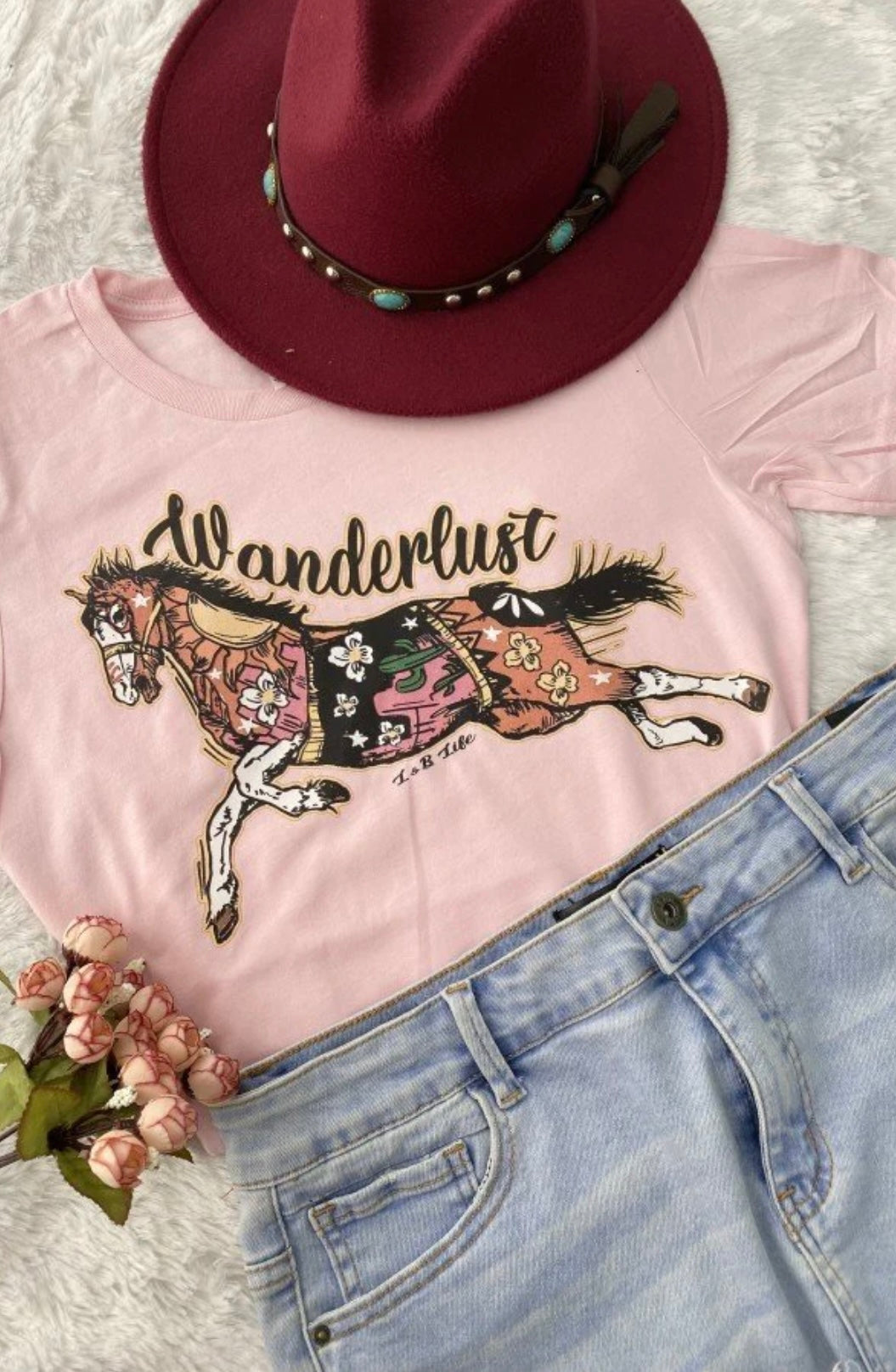 Light pink women’s tee shirt with a horse design that reads Wanderlust