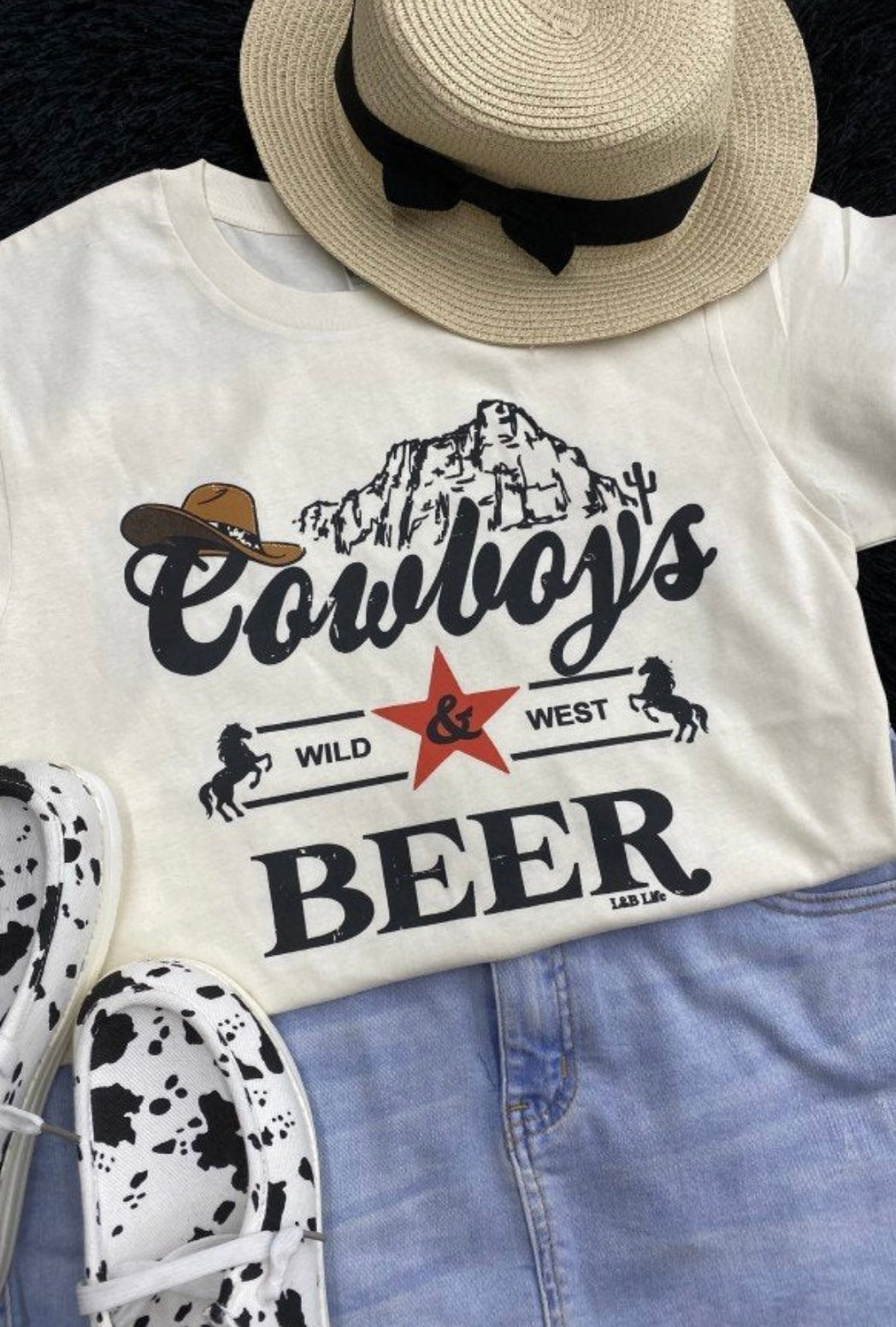 Cream colored women’s graphic tee that reads “Cowboy’s Beer Wild West”