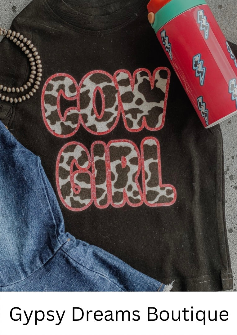 Black little girls tee with COWGIRL text in black and white cow print and pink border
